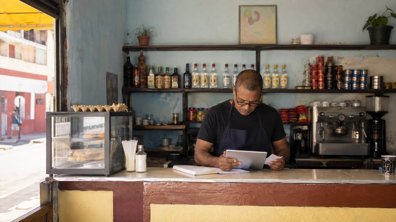 Dueño de un pequeño negocio privado en Cuba revisa los documentos de su licencia comercial tras la entrada en vigor del Registro Central Comercial