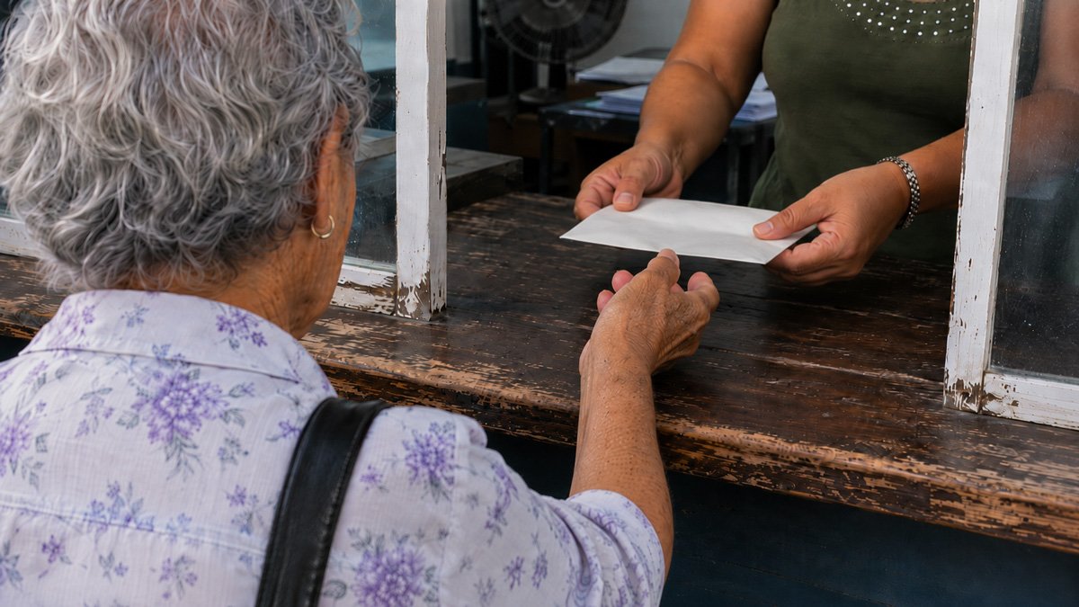 Jubilado cubano cobrando su pensión en efectivo con billetes reales de pesos cubanos (CUP)