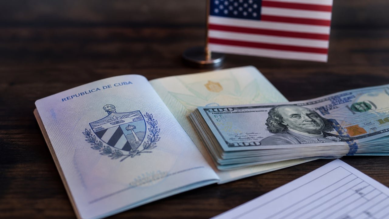Pasaporte cubano y billetes de cien dólares que representan la fianza de visa que Estados Unidos exige a los cubanos y que se pierde al pedir asilo